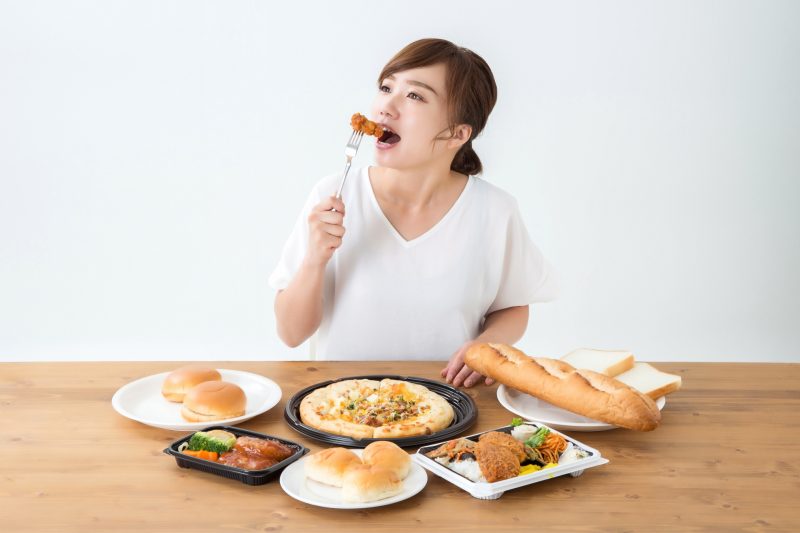 食用油で調理した料理を食べている女性